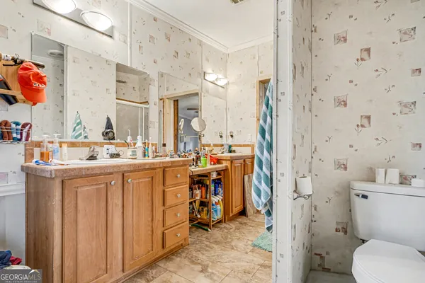 a bathroom with a sink vanity mirror and toilet