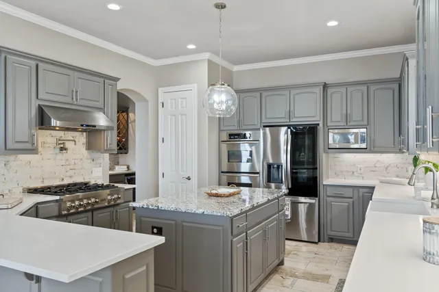 a kitchen with granite countertop a sink stove and refrigerator