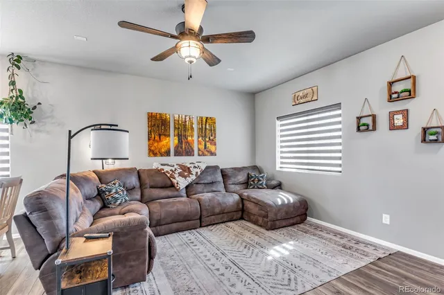 a living room with furniture ceiling fan and a window