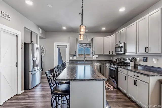 a kitchen with granite countertop a center island stainless steel appliances cabinets and a counter top space