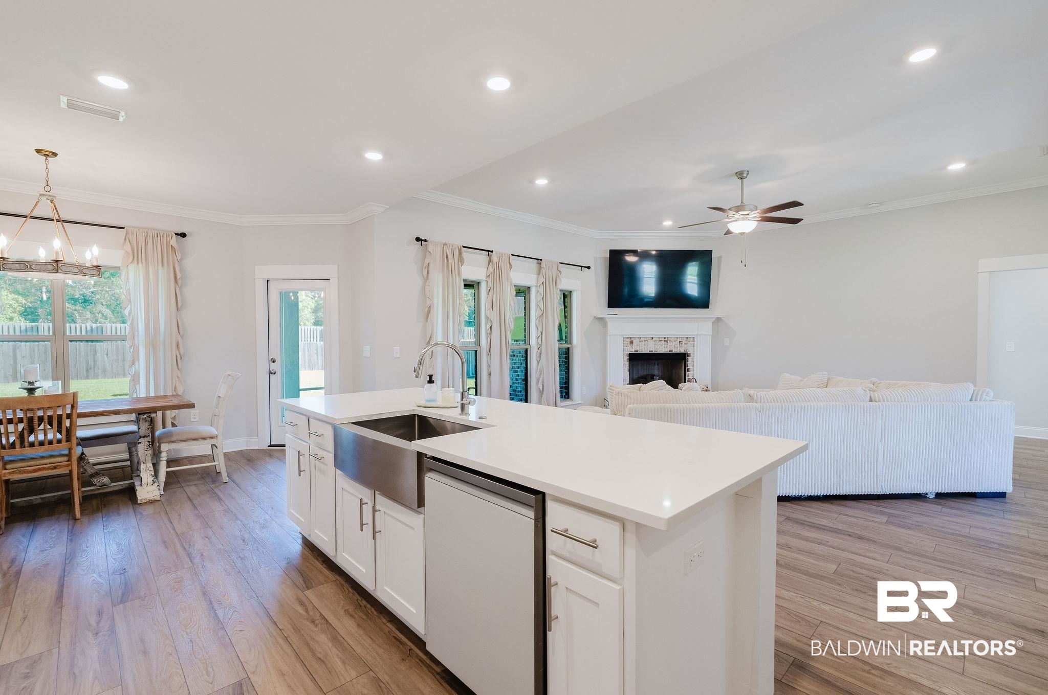 7872 Calverton Street Foley, AL 36535 - Photo 38 of 76 Kitchen island featuring a farmhouse sink, white cabinetry, and a light-toned countertop