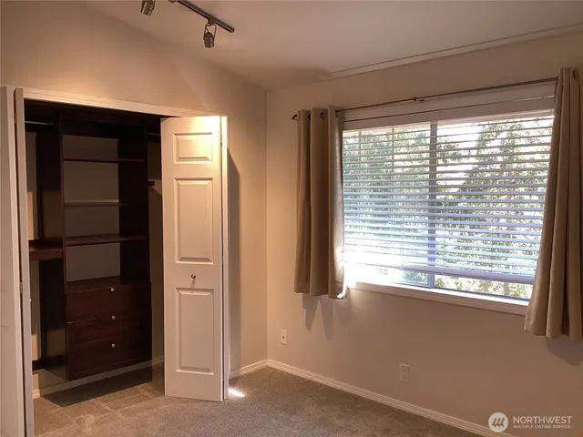 a view of an empty room with a window and closet