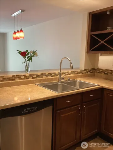 a view of a sink a microwave and cabinets