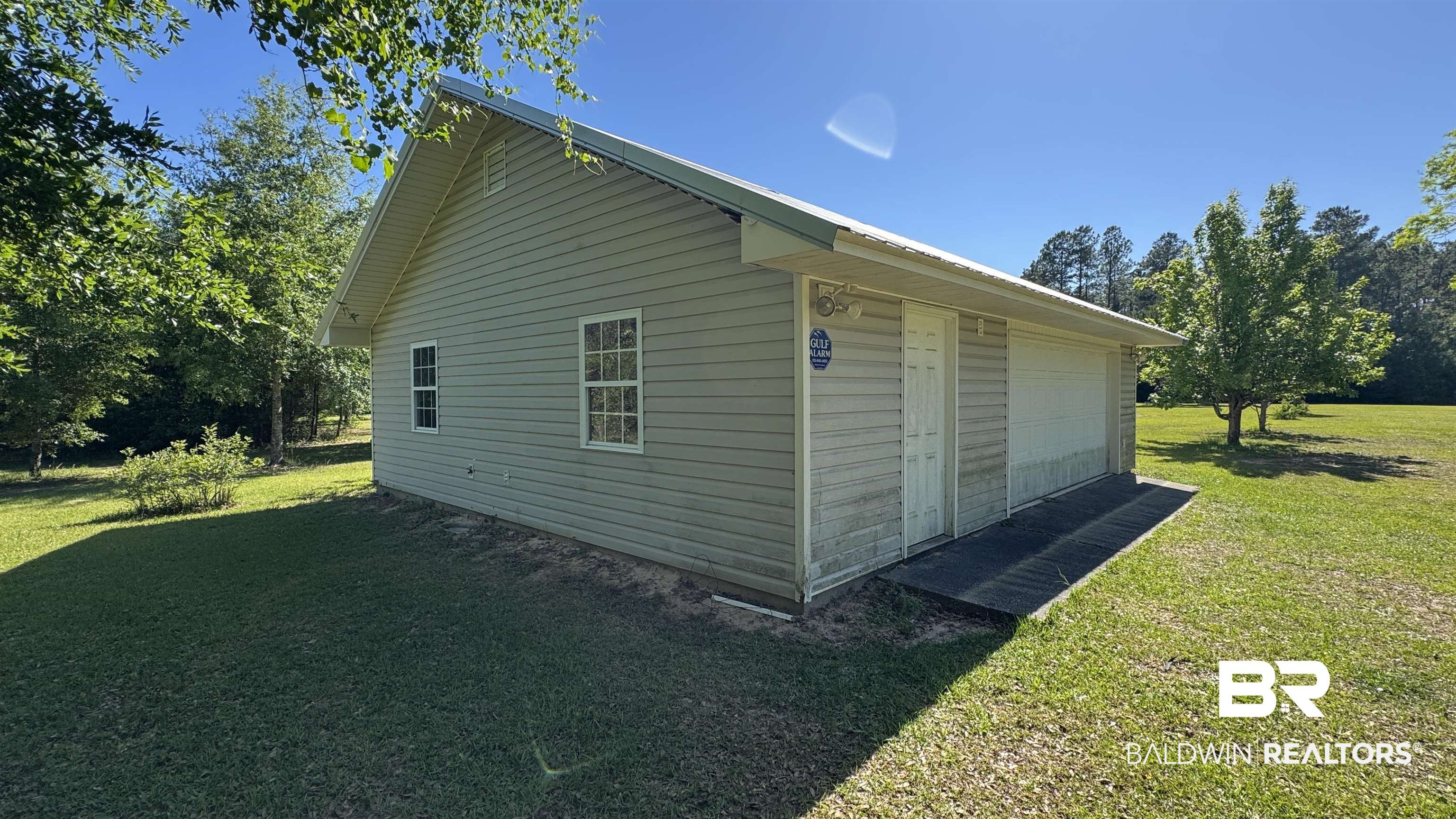 33370 Highway 98 Lillian, AL 36549 - Photo 16 of 58 Standalone structure featuring light-colored vinyl siding, a metal roof, and multiple windows