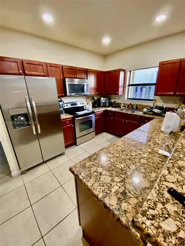 a kitchen with stainless steel appliances kitchen island granite countertop a sink and cabinets