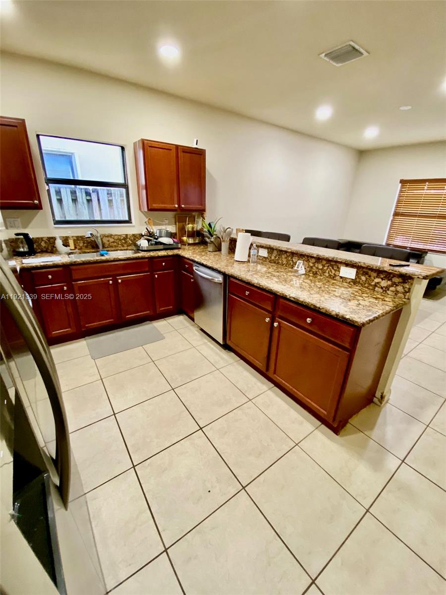 4318 Southwest 164th Court Miami, FL 33185 - Photo 6 of 27 a kitchen with stainless steel appliances granite countertop a stove a sink and a microwave