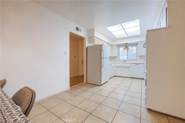 a kitchen with granite countertop a refrigerator and a stove top oven