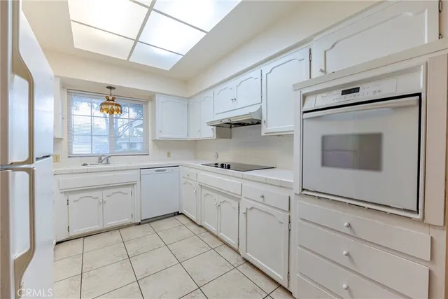 a kitchen with white cabinets appliances and sink