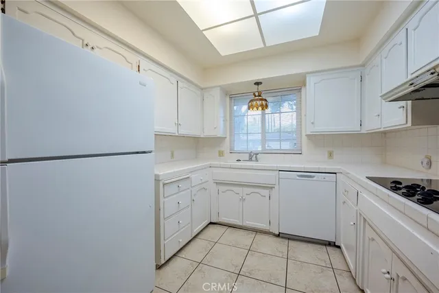 a kitchen with white cabinets and appliances