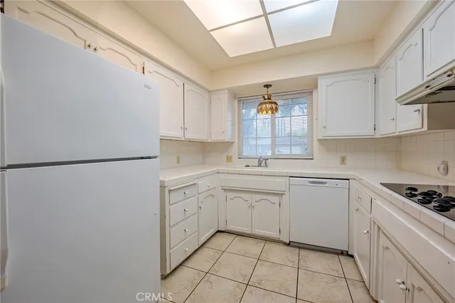 a kitchen with white cabinets and white appliances