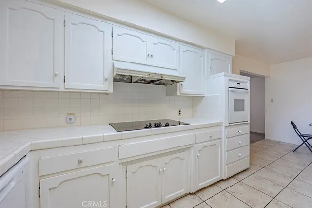 a kitchen with white cabinets and white appliances