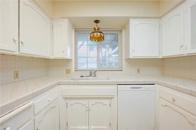 a kitchen with stainless steel appliances white cabinets and a sink
