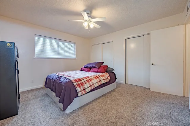 a bedroom with a bed and a ceiling fan