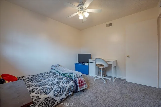 a bedroom with a bed and a chandelier fan
