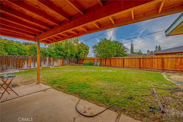 a view of a backyard with table and chairs a barbeque with wooden fence