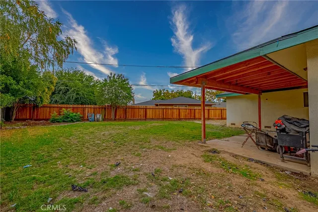 a view of a backyard with table and chairs under an umbrella