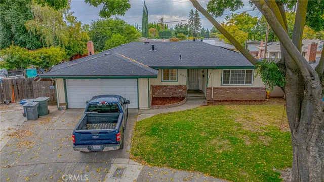 a front view of a house with a garden and trees