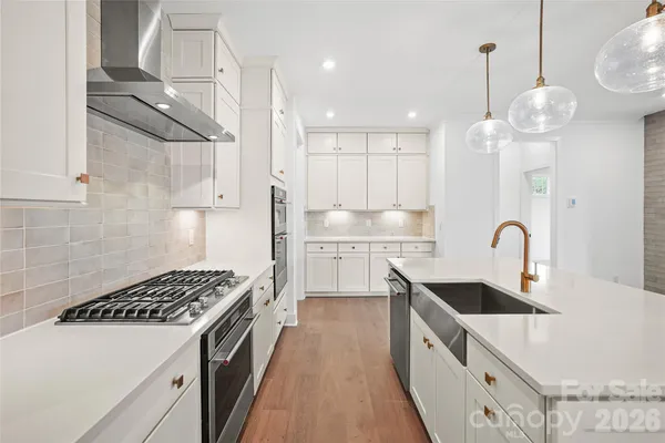 a kitchen with stainless steel appliances granite countertop a sink a stove and a refrigerator