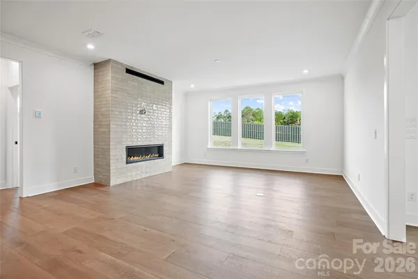 an empty room with windows and fireplace