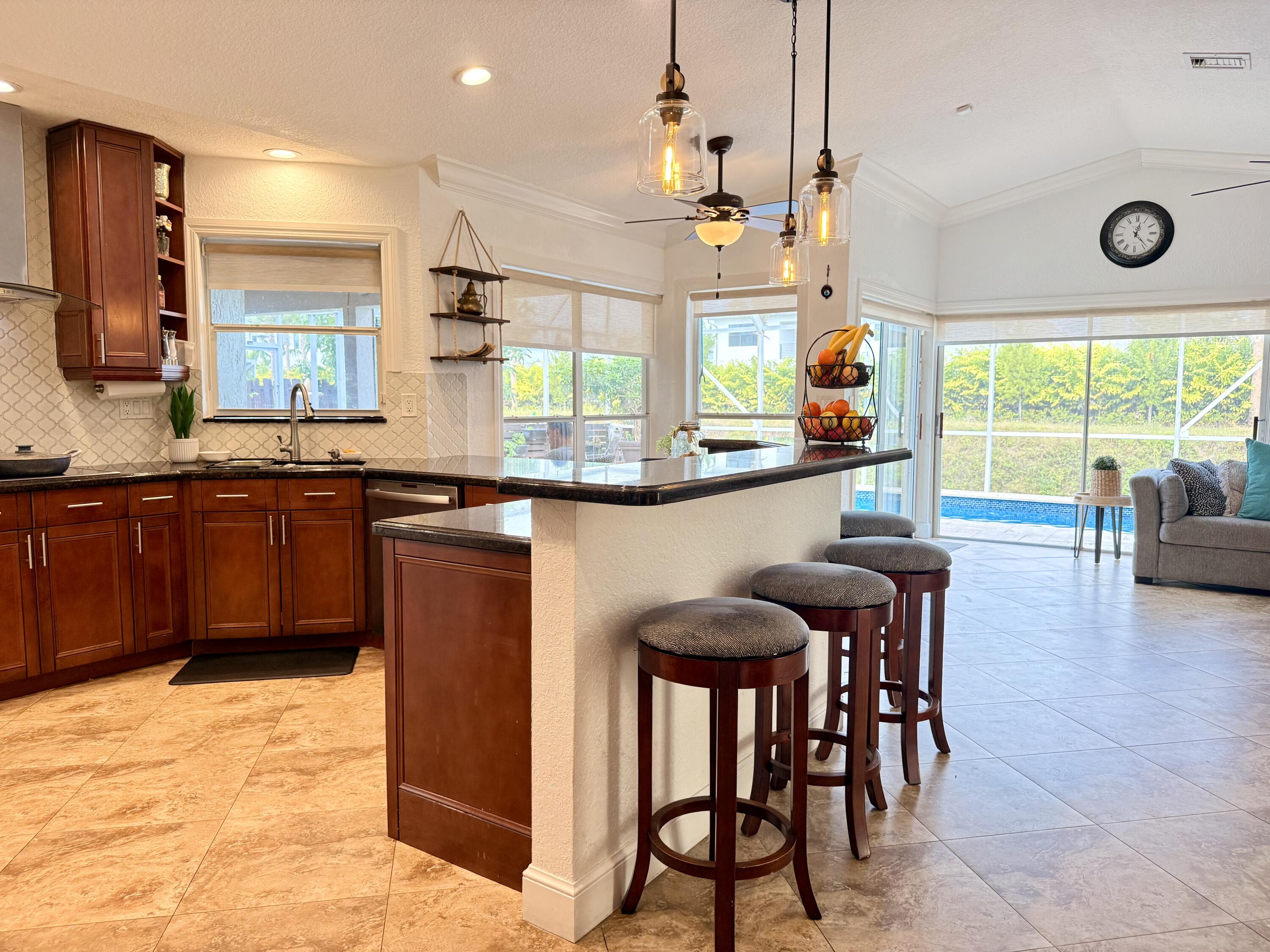 9669 Carousel Circle North Boca Raton, FL 33434 - Photo 19 of 22 a kitchen with stainless steel appliances granite countertop wooden floor a dining table and chairs
