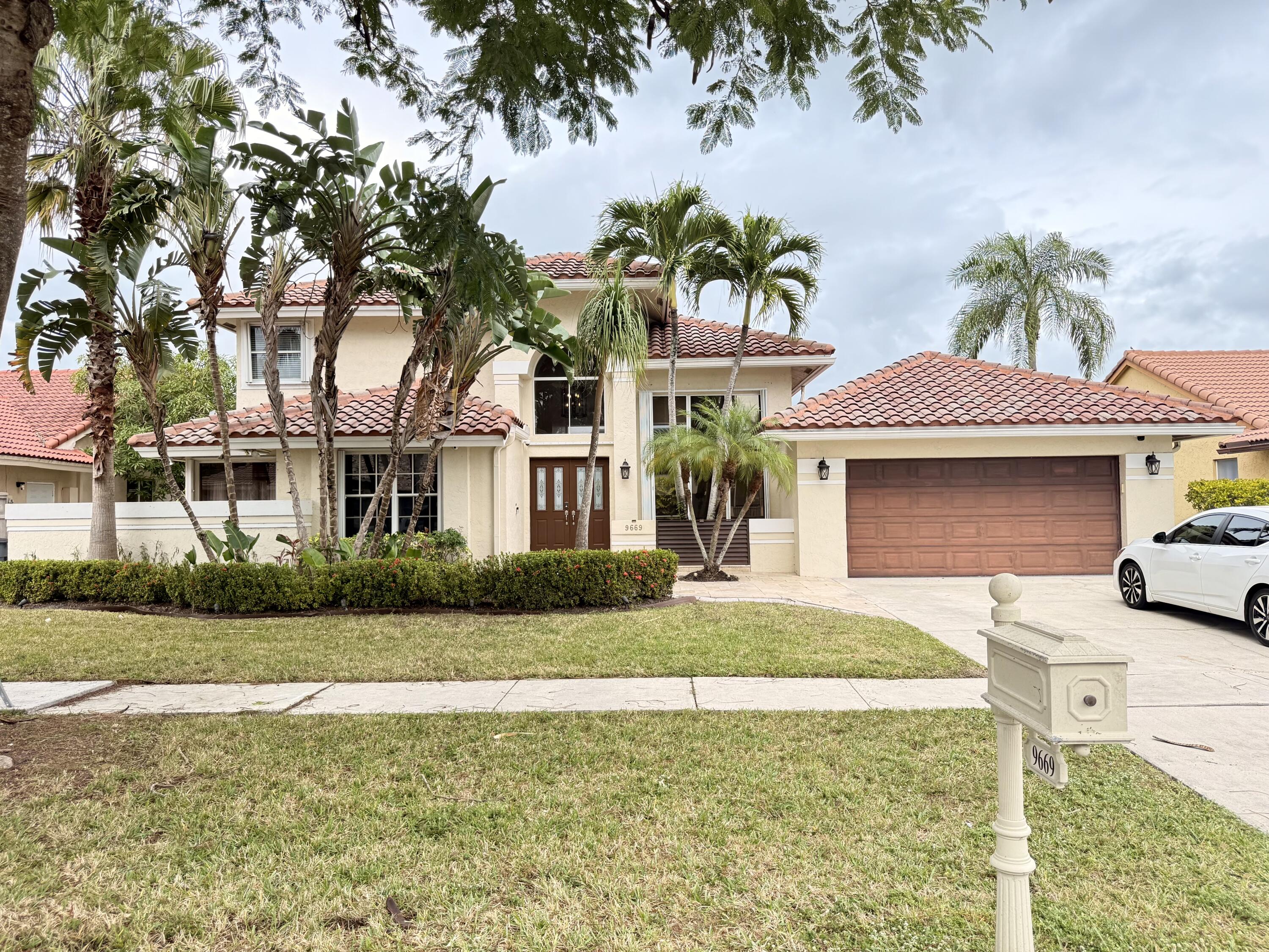 9669 Carousel Circle North Boca Raton, FL 33434 - Photo 2 of 22 a front view of a house with garden