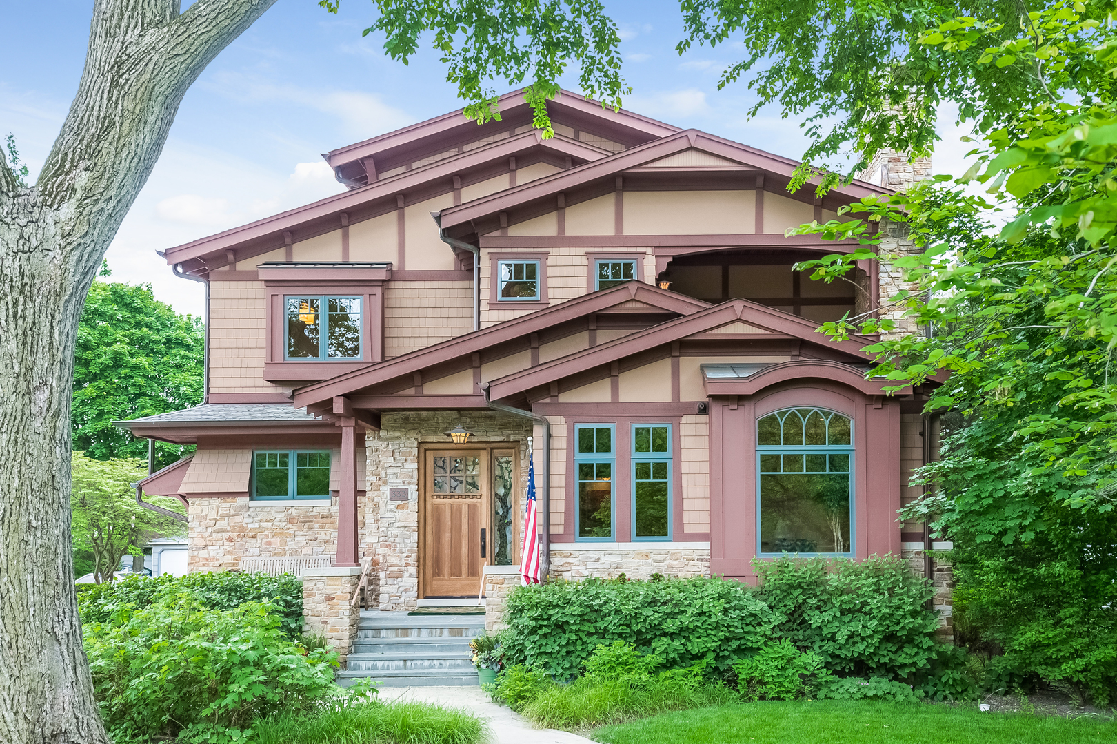 a view of a brick house with a large windows and large trees