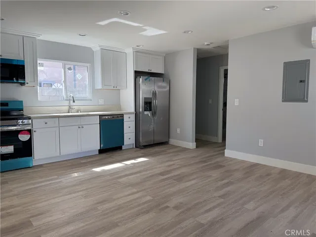 a view of a kitchen with a sink and a refrigerator