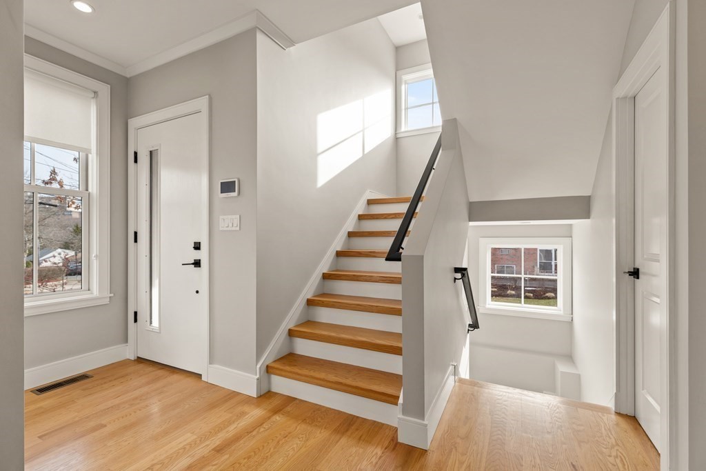373 Langley Road, Unit 1 Newton, MA 02459 - Photo 12 of 29 a view of a hallway with wooden floor and entryway