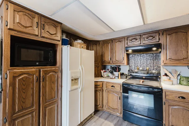 a kitchen with stainless steel appliances granite countertop a stove microwave and refrigerator