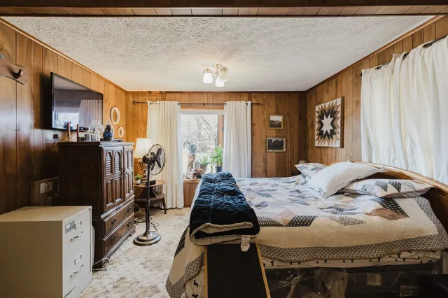 a bedroom with a bed and flat screen tv