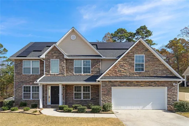 a front view of a house with a yard and garage