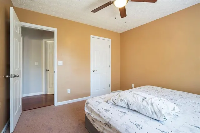 a bedroom with a bed and a chandelier fan