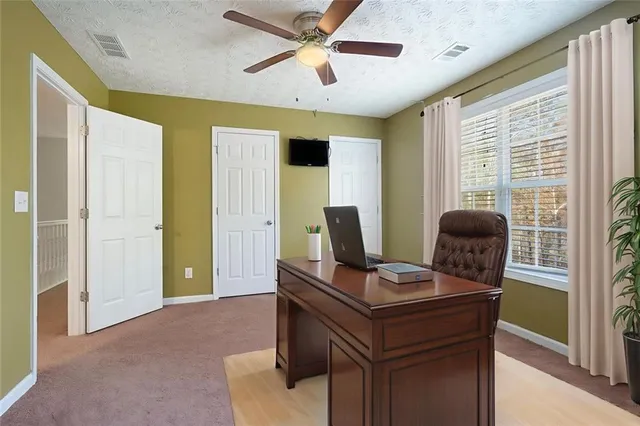 a view of a workspace with furniture and a window