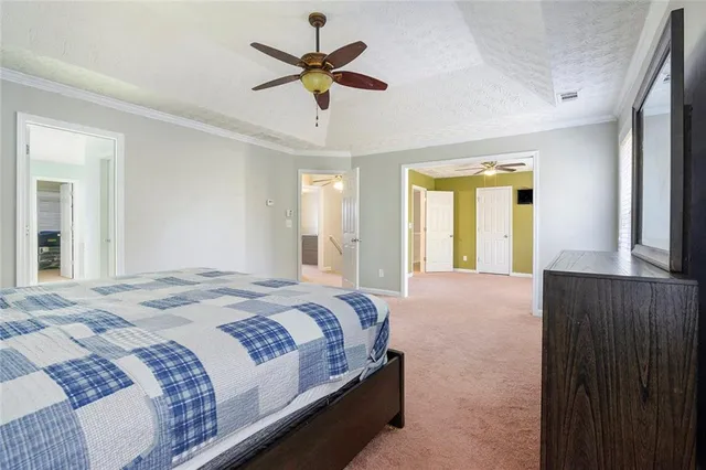 a bedroom with a large bed and a chandelier