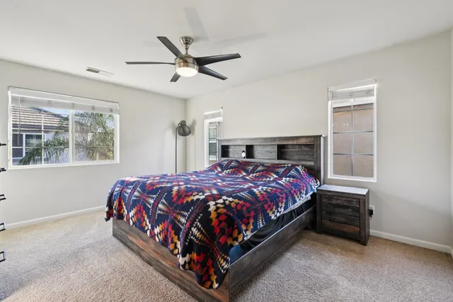 a bed sitting in a bedroom next to a window