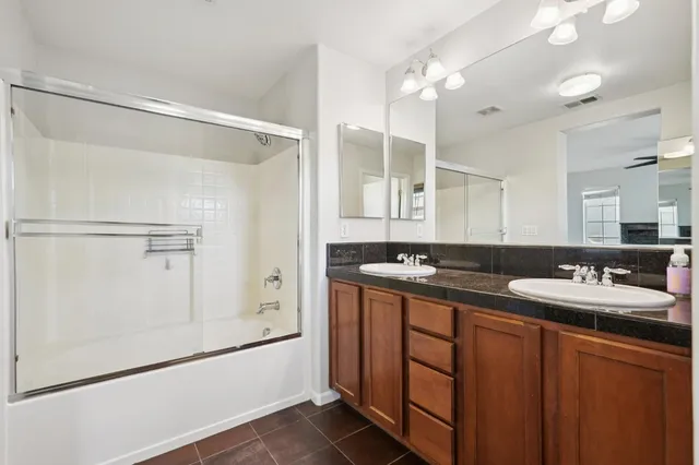 a bathroom with a double vanity sink mirror and shower