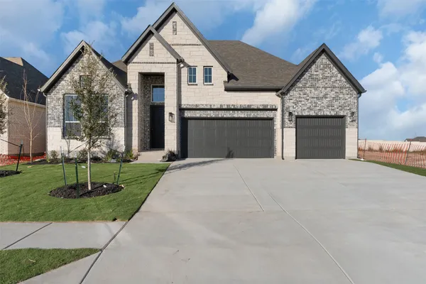 a front view of a house with a yard and trees