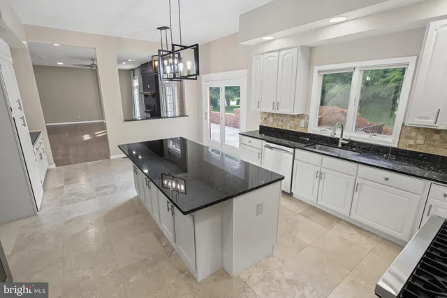 a kitchen with stainless steel appliances granite countertop a stove and white cabinets