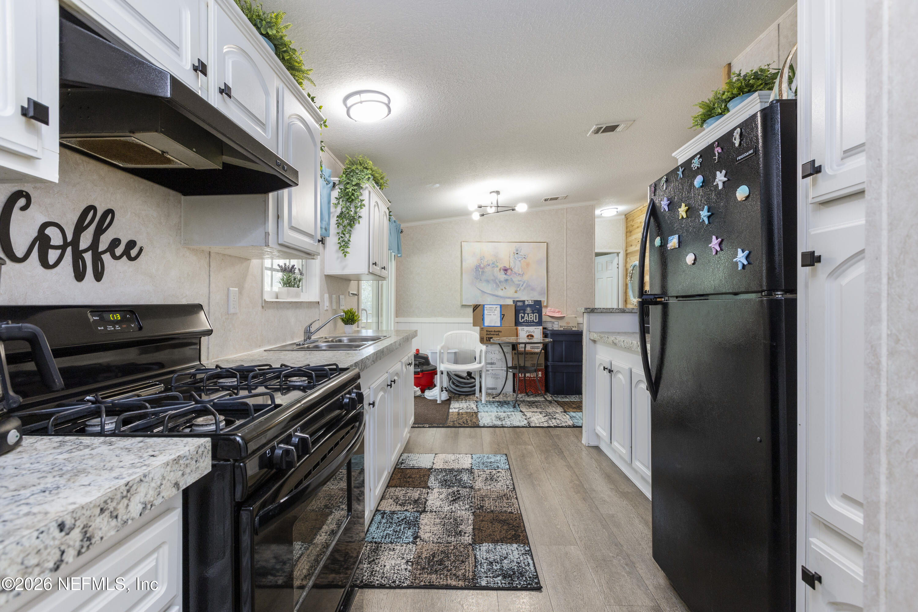 167 West Strickland Road Interlachen, FL 32148 - Photo 16 of 59 a kitchen with stainless steel appliances granite countertop a refrigerator a stove and a sink with wooden floor