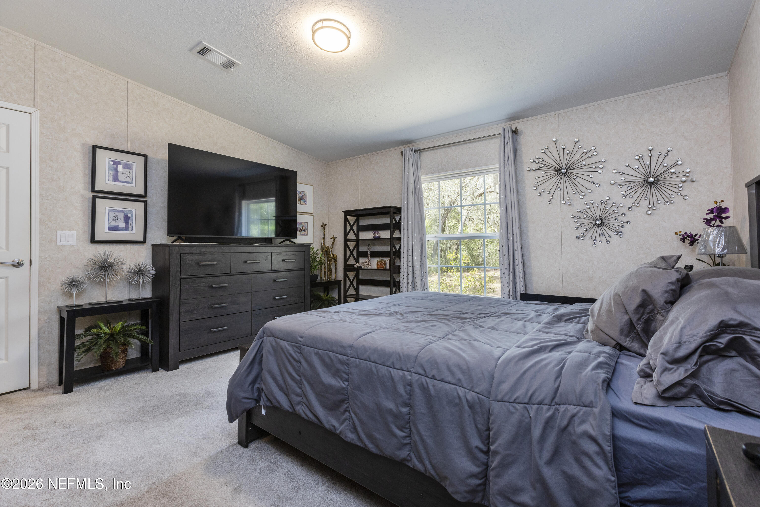 167 West Strickland Road Interlachen, FL 32148 - Photo 37 of 59 a spacious bedroom with a bed and a flat screen tv