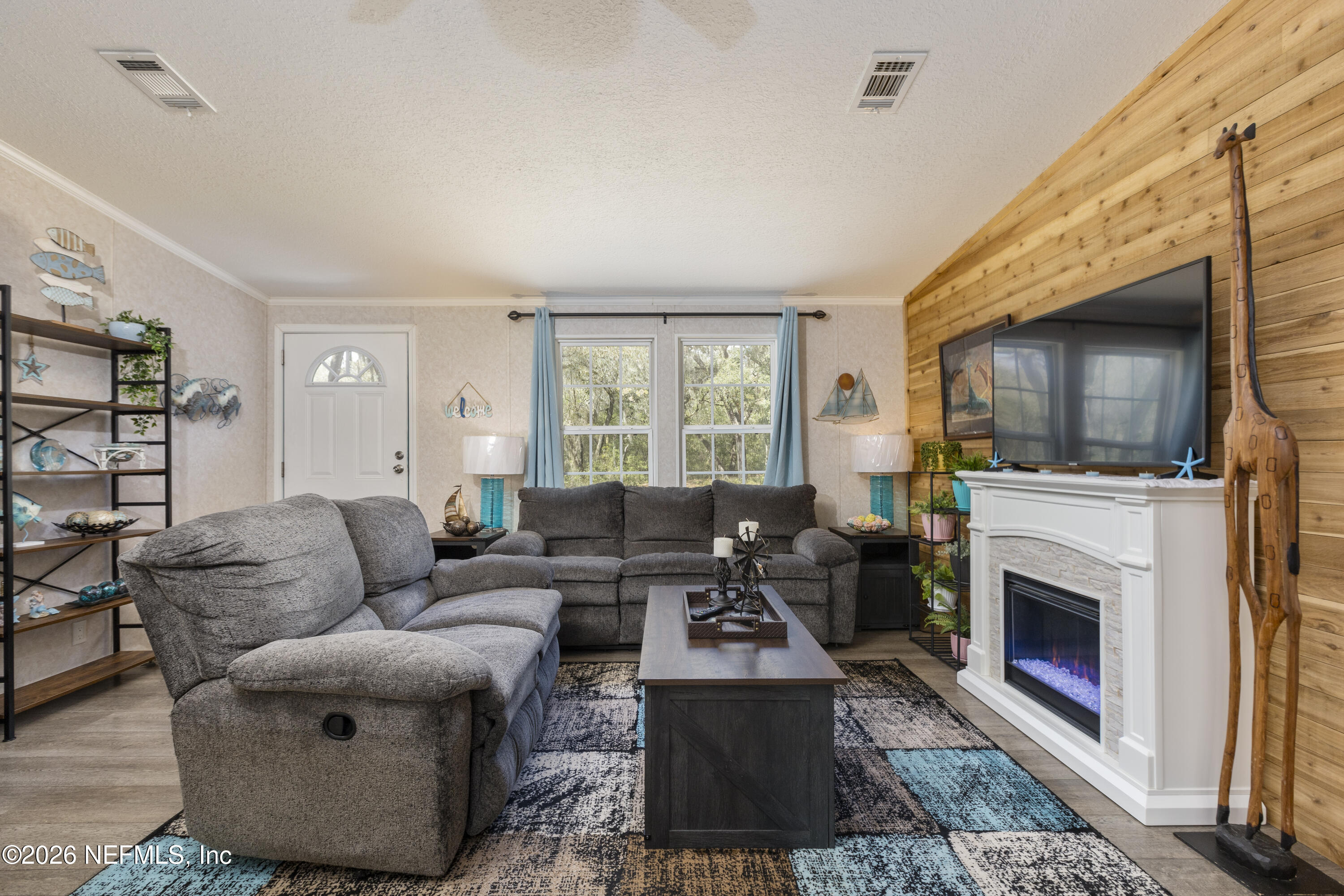 167 West Strickland Road Interlachen, FL 32148 - Photo 7 of 59 a living room with furniture a flat screen tv and a fireplace