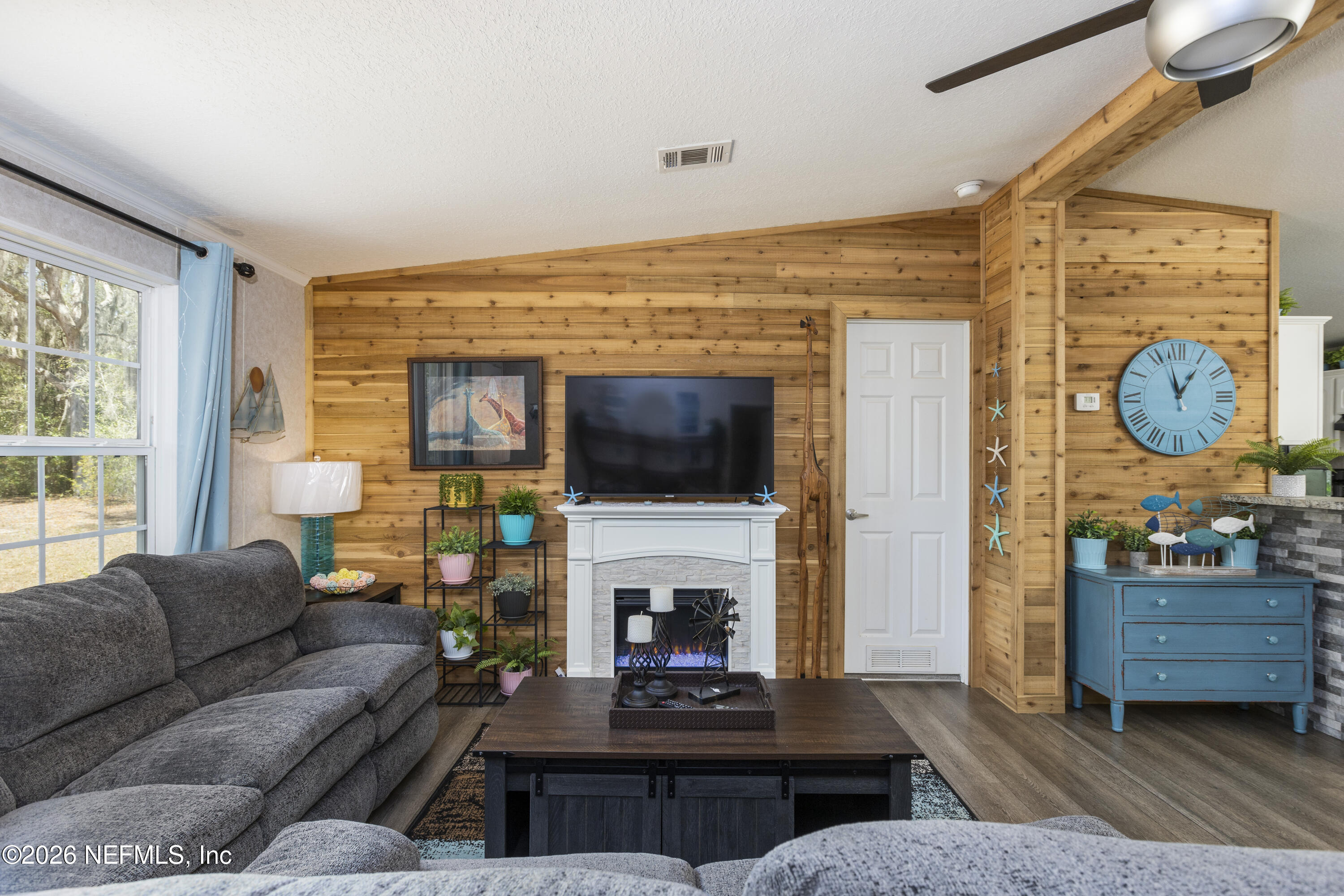 167 West Strickland Road Interlachen, FL 32148 - Photo 8 of 59 a living room with furniture a flat screen tv and a fireplace