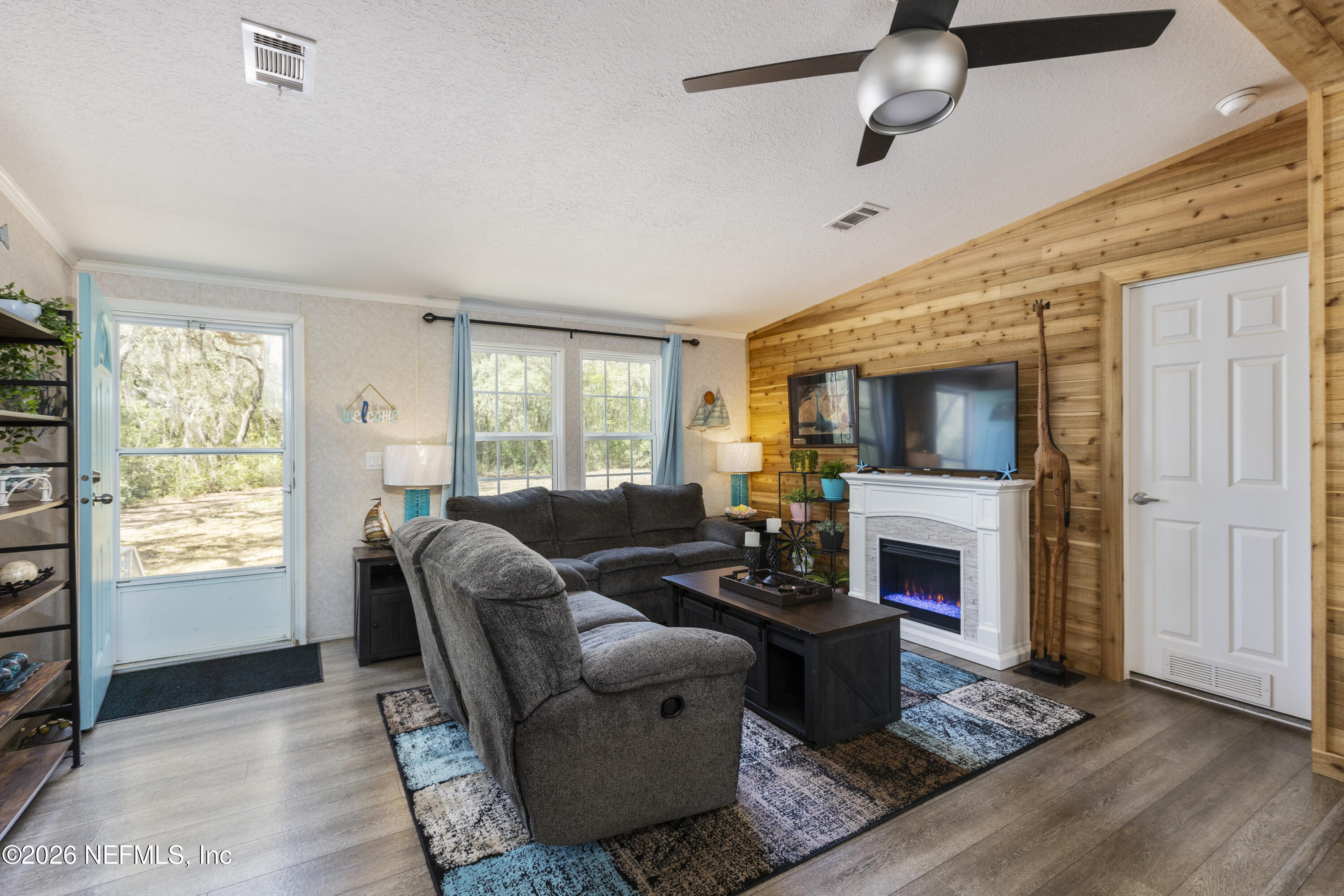 167 West Strickland Road Interlachen, FL 32148 - Photo 9 of 59 a living room with furniture a flat screen tv and a fireplace