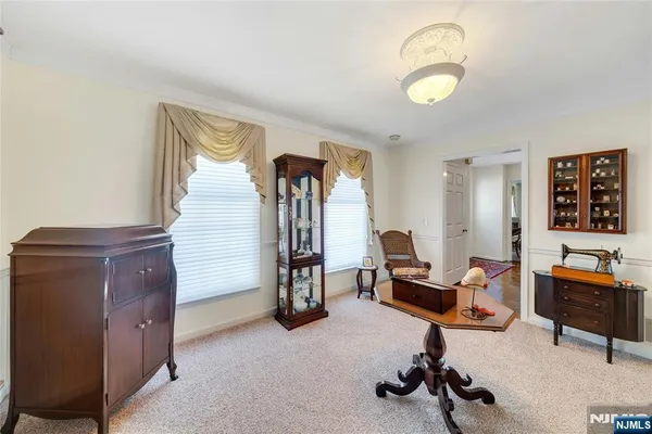 a view of a livingroom with workspace and a ceiling fan