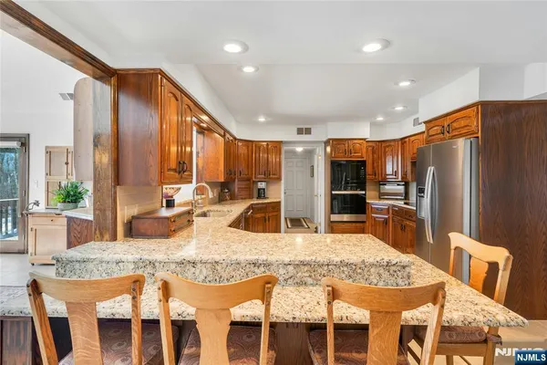 a kitchen with granite countertop a sink stainless steel appliances and cabinets