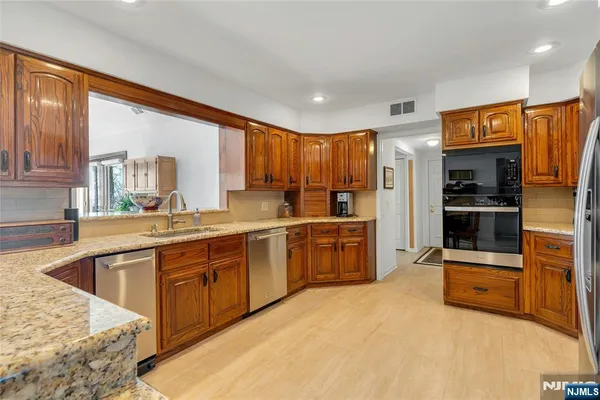 a kitchen with stainless steel appliances a refrigerator and a stove top oven