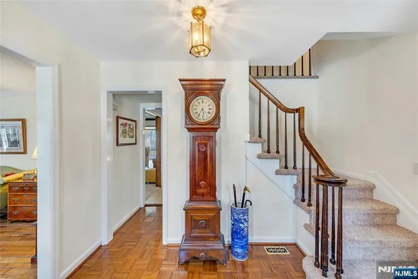 a view of a hallway with entryway and wooden floor