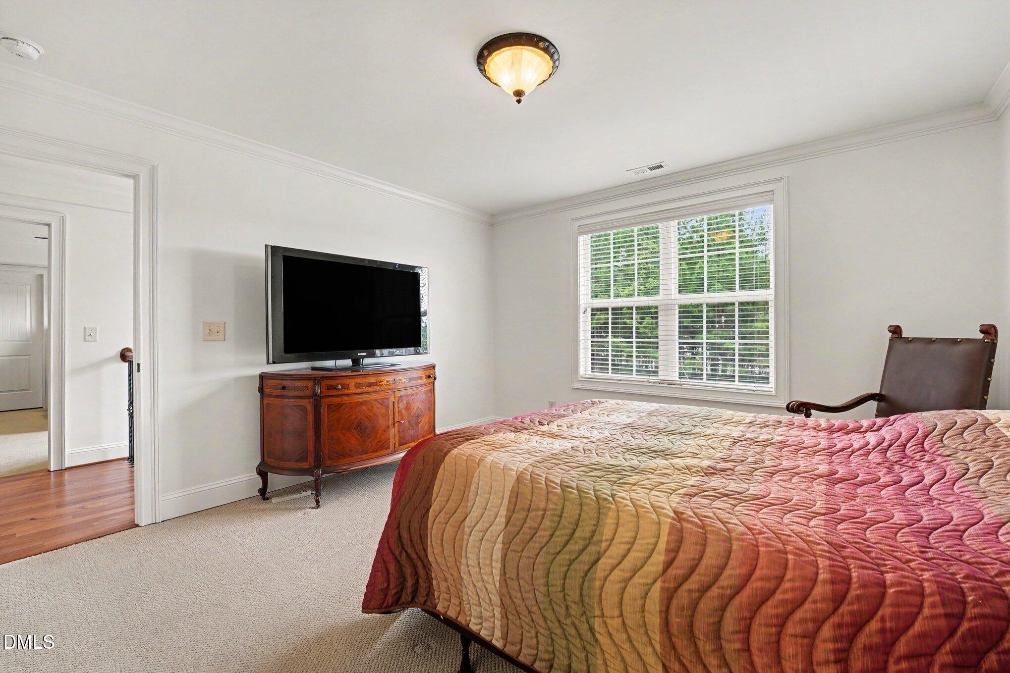1729 Frenchwood Drive Raleigh, NC 27612 - Photo 22 of 46 a bedroom with a bed and a flat screen tv