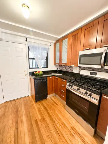 a kitchen with stainless steel appliances granite countertop a stove a sink and a microwave