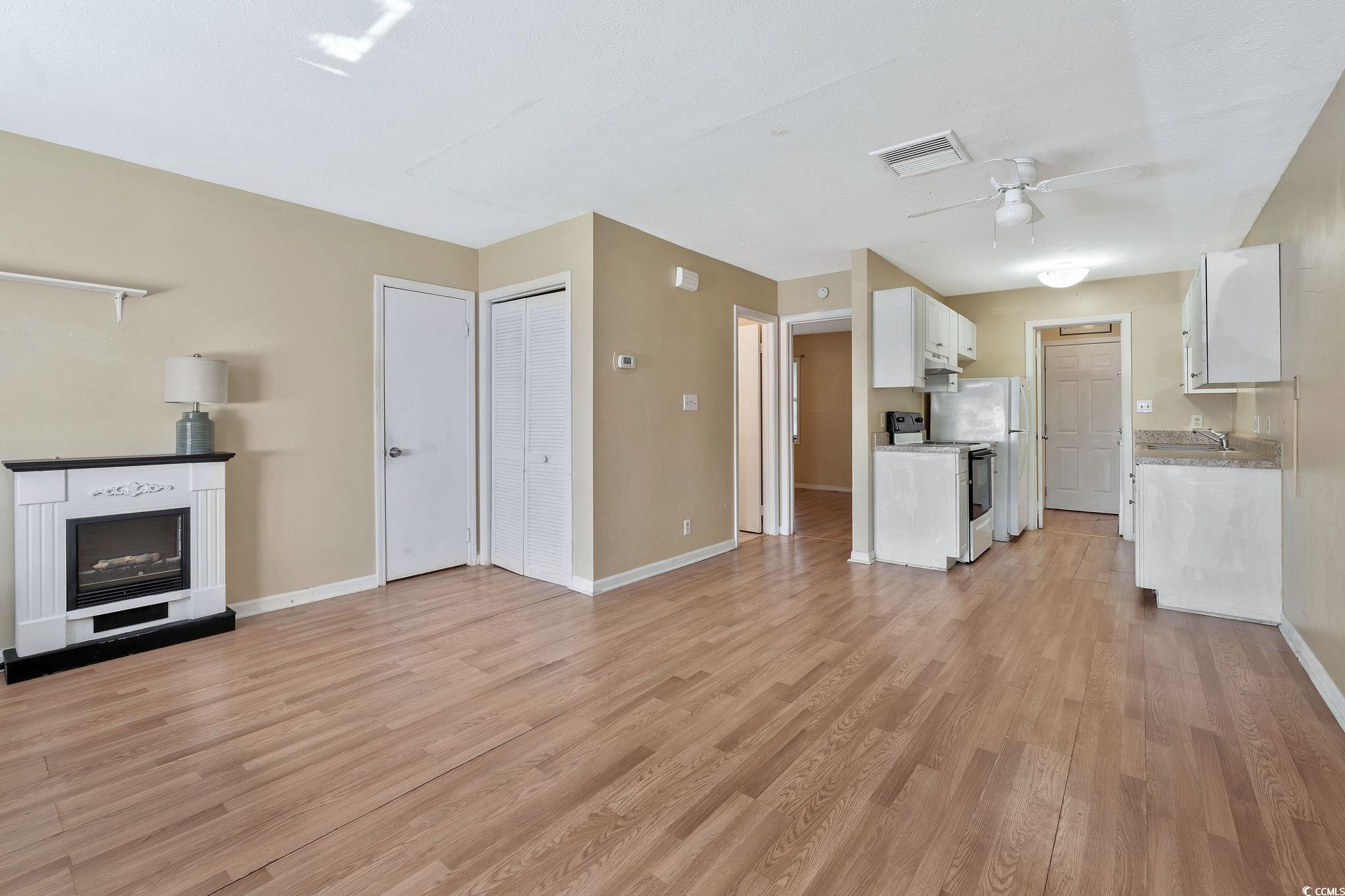 Kitchen featuring ceiling fan, sink, light hardwoo